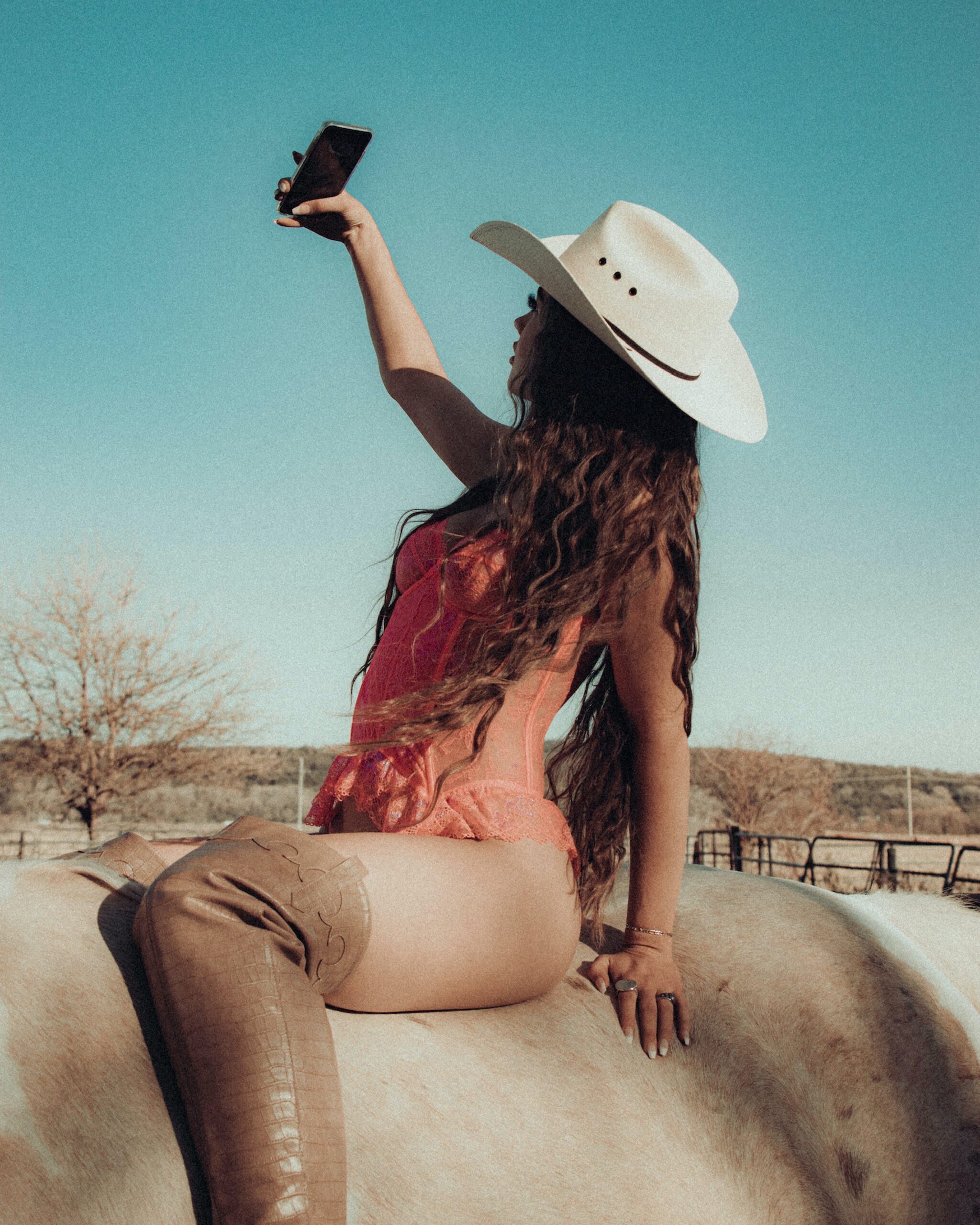 A woman taking a selfie on a horse
