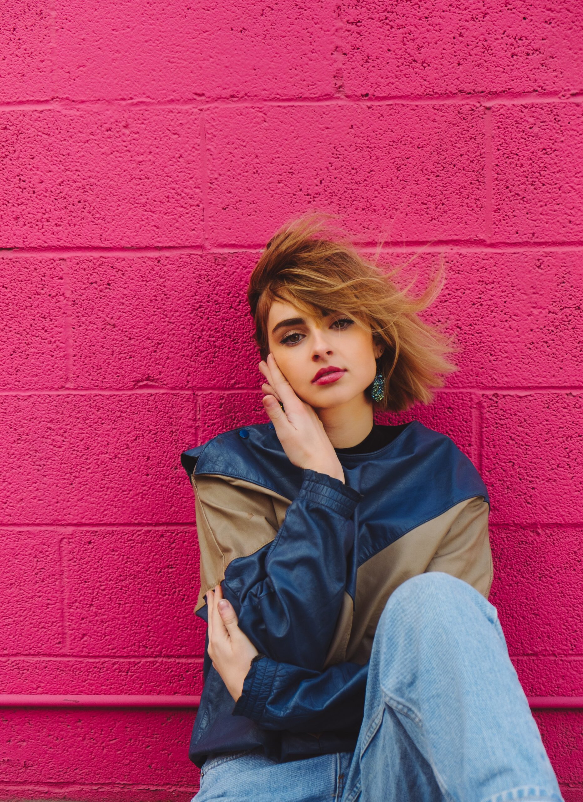 A woman posing in front of a wall